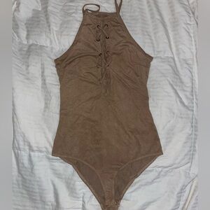 Tan bodysuit with strap detailing in the front.
